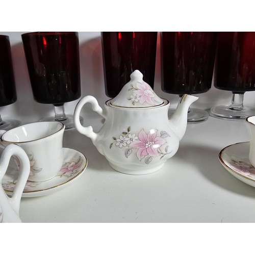 101 - A shelf of collectable items to include a set of 6 sherry ruby glasses, Royal commemorative mugs, a ... 