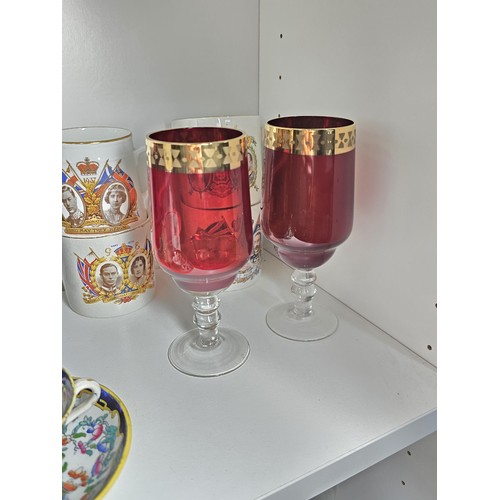 101 - A shelf of collectable items to include a set of 6 sherry ruby glasses, Royal commemorative mugs, a ... 