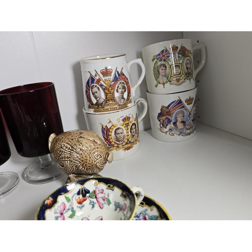 101 - A shelf of collectable items to include a set of 6 sherry ruby glasses, Royal commemorative mugs, a ... 