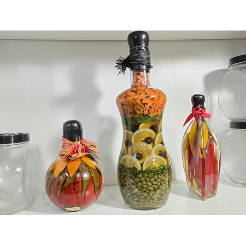 102 - 3x decorative vinegar infused fruit and vegetable bottles along with 3x empty glass kitchen storage ... 