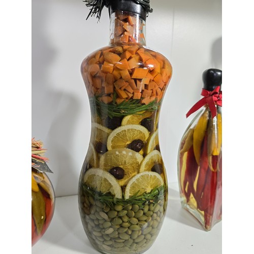 102 - 3x decorative vinegar infused fruit and vegetable bottles along with 3x empty glass kitchen storage ... 