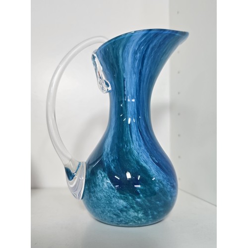 98 - A quantity of 4 studio art glass items including a mottled red vase, a blue glass jug with an ocean ... 