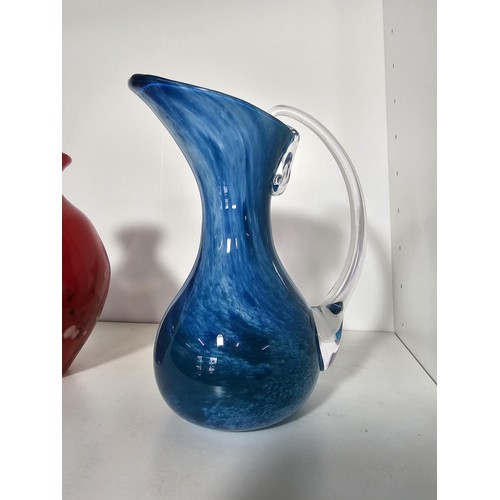 98 - A quantity of 4 studio art glass items including a mottled red vase, a blue glass jug with an ocean ... 