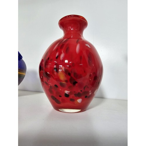 98 - A quantity of 4 studio art glass items including a mottled red vase, a blue glass jug with an ocean ... 