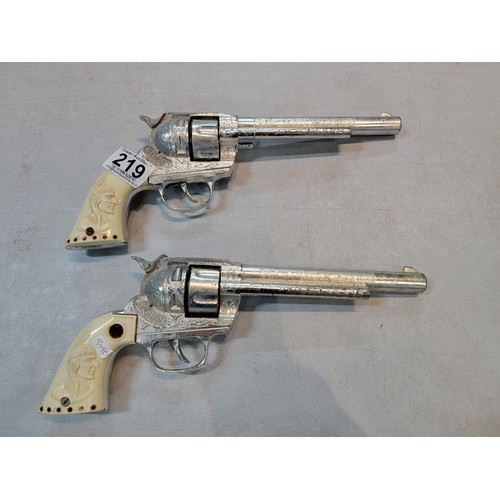 219 - Pair of vintage mid century BCM Sixgun cap gun, with red jewelled plastic handle depicting a native ... 