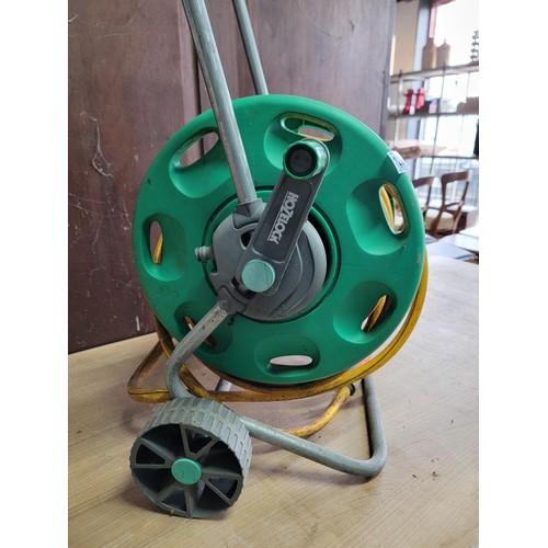 122 - Good quality Hozelock portable hose reel with a quantity of hose pipe and connector