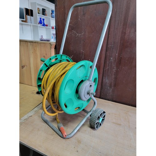 122 - Good quality Hozelock portable hose reel with a quantity of hose pipe and connector