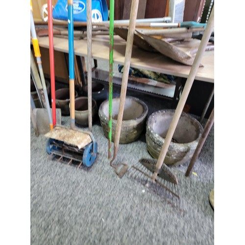 128 - Large quantity of garden tools to include spades, rakes, aerator, hoe, garden rake, brushes, lawn se... 