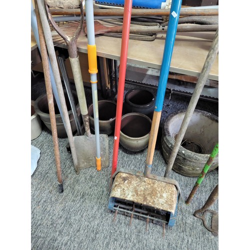 128 - Large quantity of garden tools to include spades, rakes, aerator, hoe, garden rake, brushes, lawn se... 