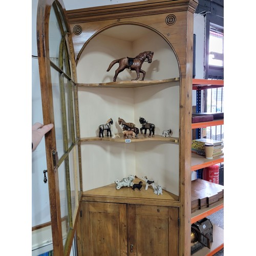 233 - A large and impressive antique pitch pine corner cabinet with a large glazed door to the front featu... 