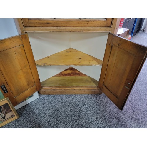 233 - A large and impressive antique pitch pine corner cabinet with a large glazed door to the front featu... 