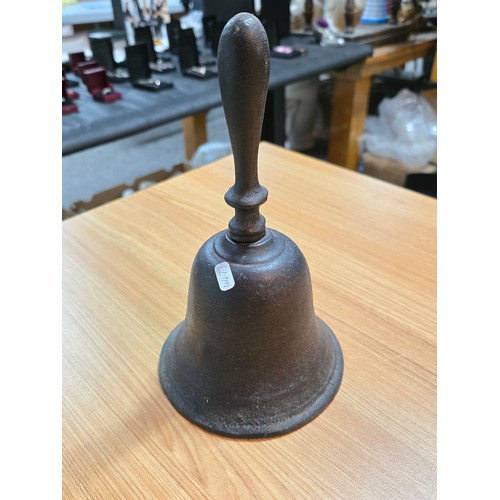 245 - An antique cast iron hand bell with a cast iron handle and a cast iron wall bracket marked Captain. ... 