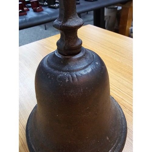 245 - An antique cast iron hand bell with a cast iron handle and a cast iron wall bracket marked Captain. ... 