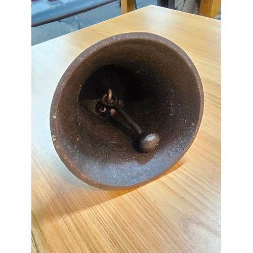 245 - An antique cast iron hand bell with a cast iron handle and a cast iron wall bracket marked Captain. ... 