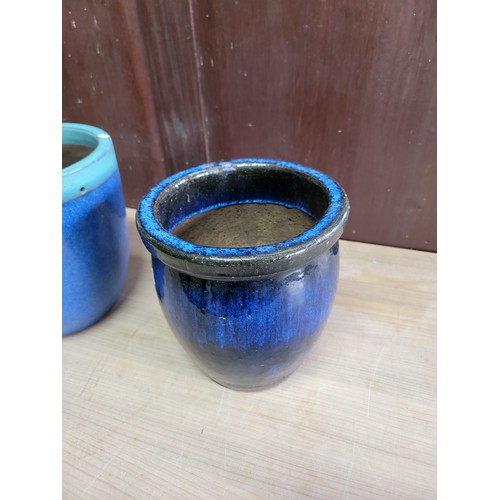 170 - 2x glazed blue planters. 1x in terracotta and the other in concrete, both in good order. Largest sta... 