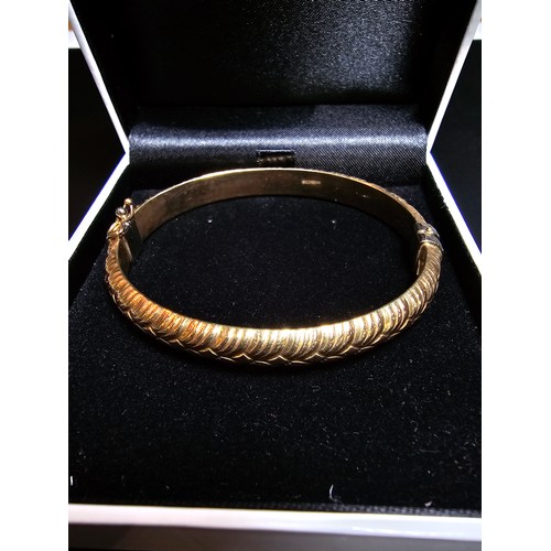 337 - A good quality hallmarked 9ct yellow gold bangle with an ornate design, opens on a spring hinge with... 