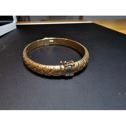 337 - A good quality hallmarked 9ct yellow gold bangle with an ornate design, opens on a spring hinge with... 