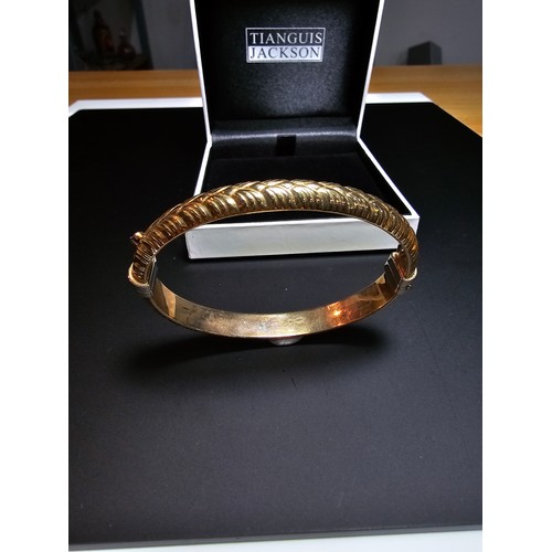 337 - A good quality hallmarked 9ct yellow gold bangle with an ornate design, opens on a spring hinge with... 