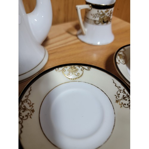 375 - A 3 person Noritake black cream and gilded coffee set with 3x coffee cans and saucers, cream jug, su... 