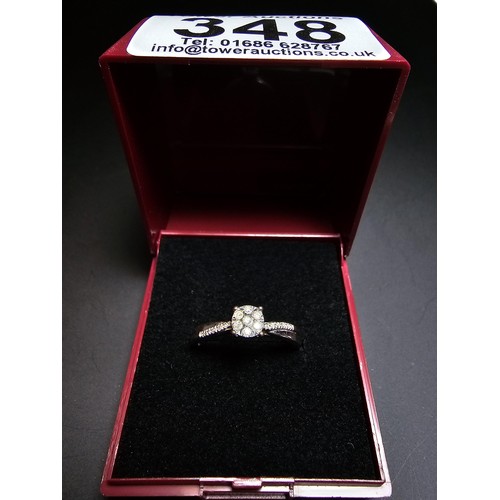 348 - A hallmarked 9ct white gold diamond ring inset with 7 diamonds to the centre with several small diam... 