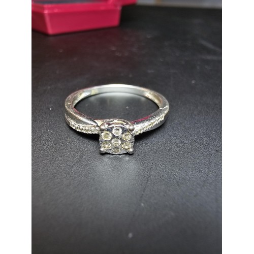 348 - A hallmarked 9ct white gold diamond ring inset with 7 diamonds to the centre with several small diam... 