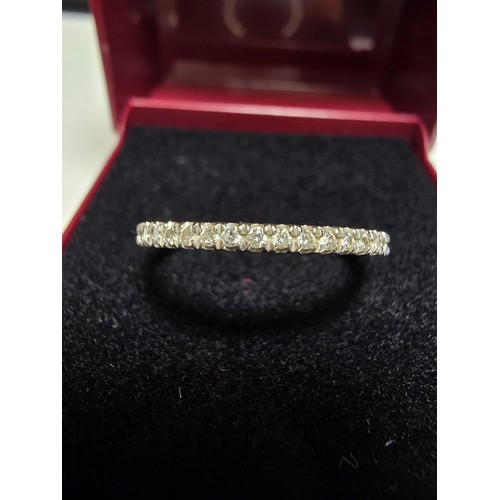 349 - A hallmarked 18ct white gold half eternity ring inset half way around with a large quantity of real ... 