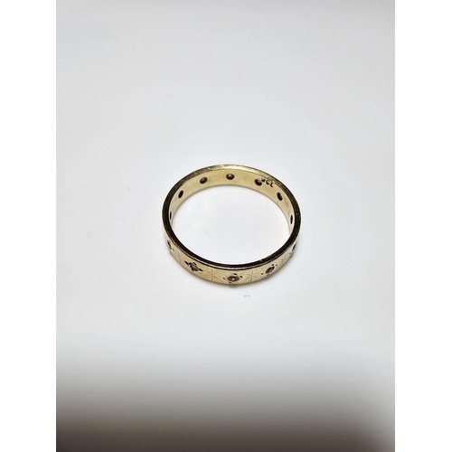 350 - A 9ct yellow gold ring inset with faceted rock crystal gemstones all the way around featuring an eng... 