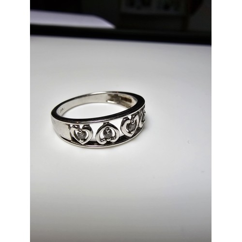 351 - A hallmarked 9ct white gold ring inset with 5 diamonds in heart shaped mounts, in excellent clean co... 