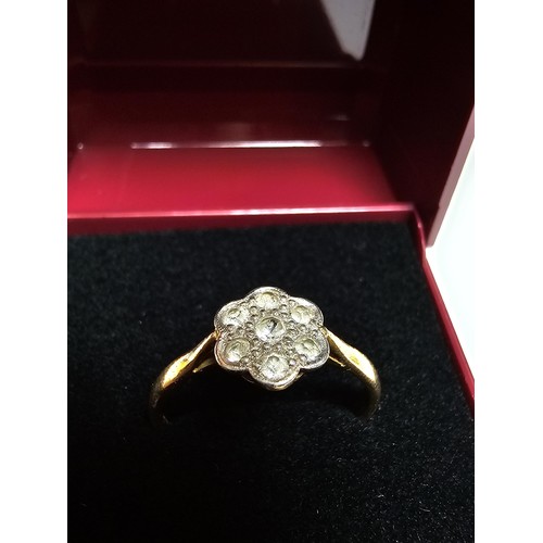 354 - A pretty 18ct yellow gold ring with a flower design inset with 7 white topaz gemstones and marked 18... 