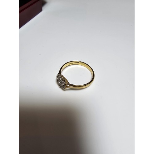 354 - A pretty 18ct yellow gold ring with a flower design inset with 7 white topaz gemstones and marked 18... 