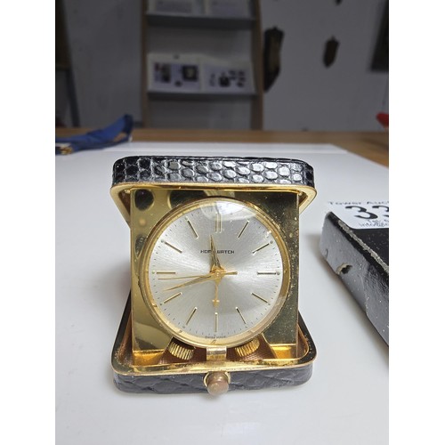 335 - A pretty small cased travel clock with a mechanical movement on a sweeping second hand marked to the... 