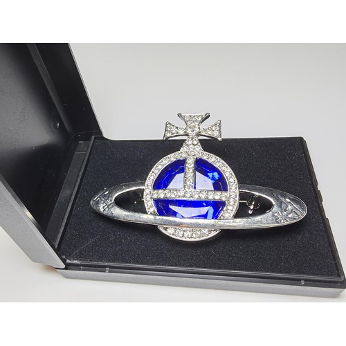 274 - A vintage Vivian Westwood blue orb silver tone brooch having a large blue crystal to the centre surr... 