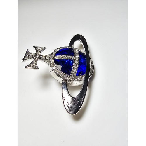 274 - A vintage Vivian Westwood blue orb silver tone brooch having a large blue crystal to the centre surr... 