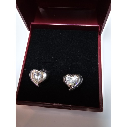 277 - A pair of 925 silver heart formed stud earrings inset with a large sparkly crystal CZ stone. In good... 