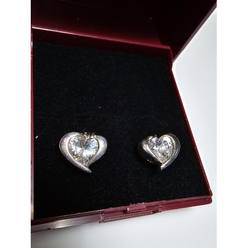 277 - A pair of 925 silver heart formed stud earrings inset with a large sparkly crystal CZ stone. In good... 