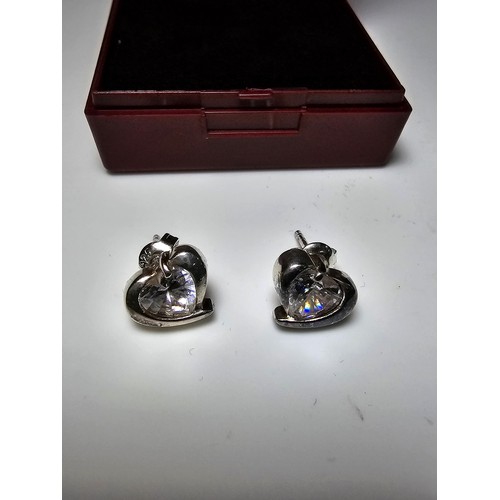 277 - A pair of 925 silver heart formed stud earrings inset with a large sparkly crystal CZ stone. In good... 