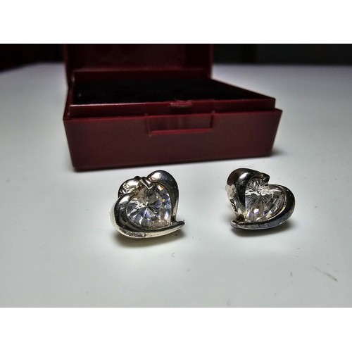 277 - A pair of 925 silver heart formed stud earrings inset with a large sparkly crystal CZ stone. In good... 