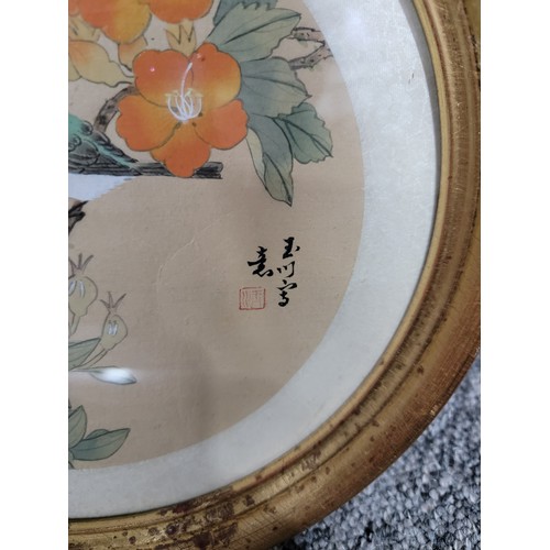 406 - 2x circular framed and glazed silk oriental pictures of birds both are signed along with a large gil... 