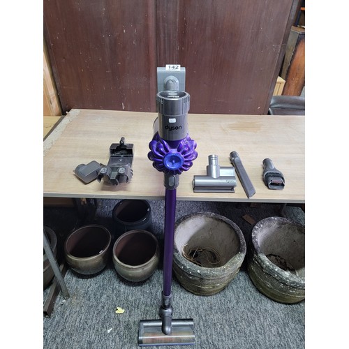 142 - Dyson vacuum cleaner in working order with a quantity of accessories and wall mount, Dyson will requ... 