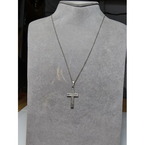 286 - An ornate 925 silver cross pendant with an engraved design set on a long 22