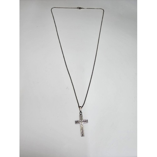 286 - An ornate 925 silver cross pendant with an engraved design set on a long 22