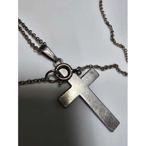 286 - An ornate 925 silver cross pendant with an engraved design set on a long 22