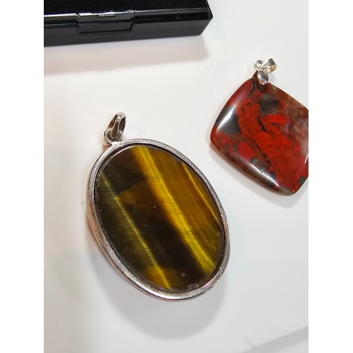 294 - 2 good quality 925 silver semi precious stone pendants to include a large oval tigers eye pendant an... 