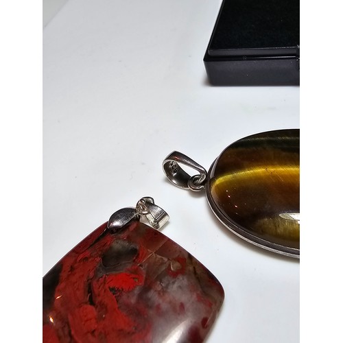 294 - 2 good quality 925 silver semi precious stone pendants to include a large oval tigers eye pendant an... 