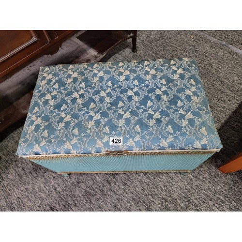 426 - Vintage lloyd loom style blanket box with padded blue floral seat to the top and metal carry handles... 