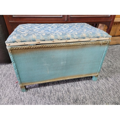 426 - Vintage lloyd loom style blanket box with padded blue floral seat to the top and metal carry handles... 