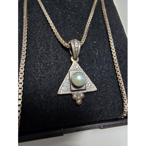 299 - An unusual 925 silver triangular pendant inset with a genuine pearl on a good long 20