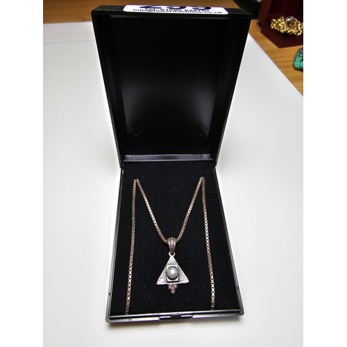 299 - An unusual 925 silver triangular pendant inset with a genuine pearl on a good long 20