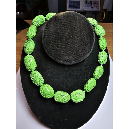 307 - An unusual green turquoise hand carved beaded necklace featuring beautiful carving from each bead pr... 