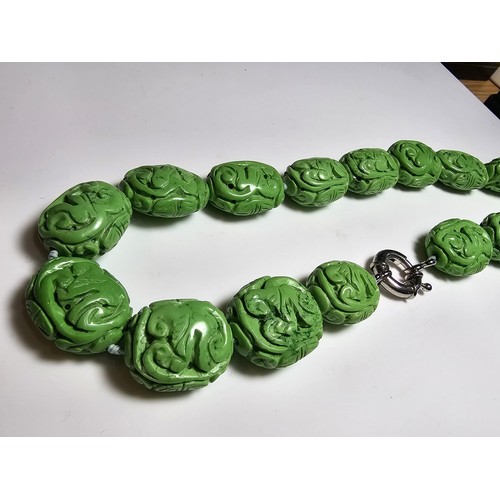 307 - An unusual green turquoise hand carved beaded necklace featuring beautiful carving from each bead pr... 